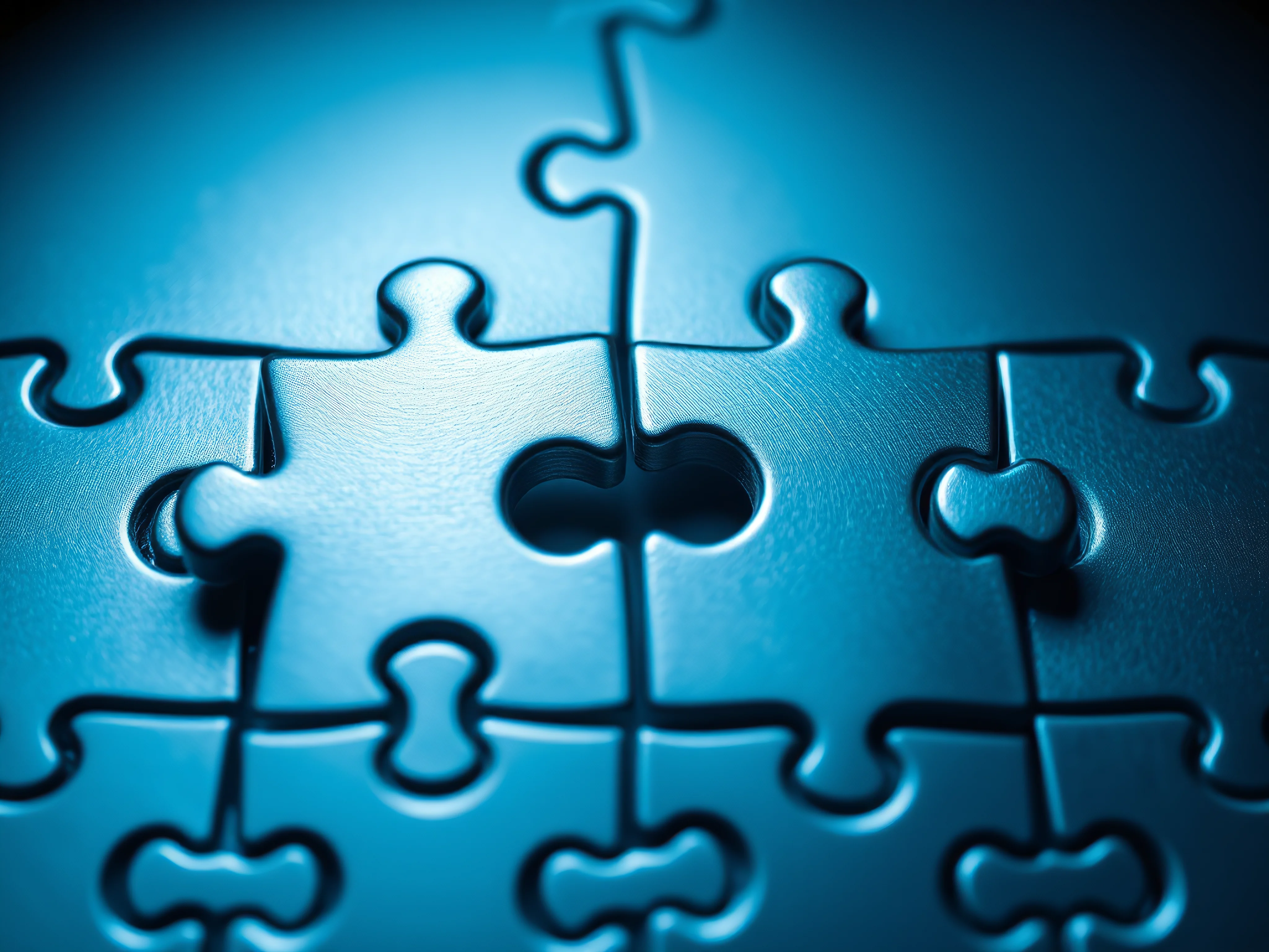Precisely interlocked metallic puzzle pieces in cool blue and silver.